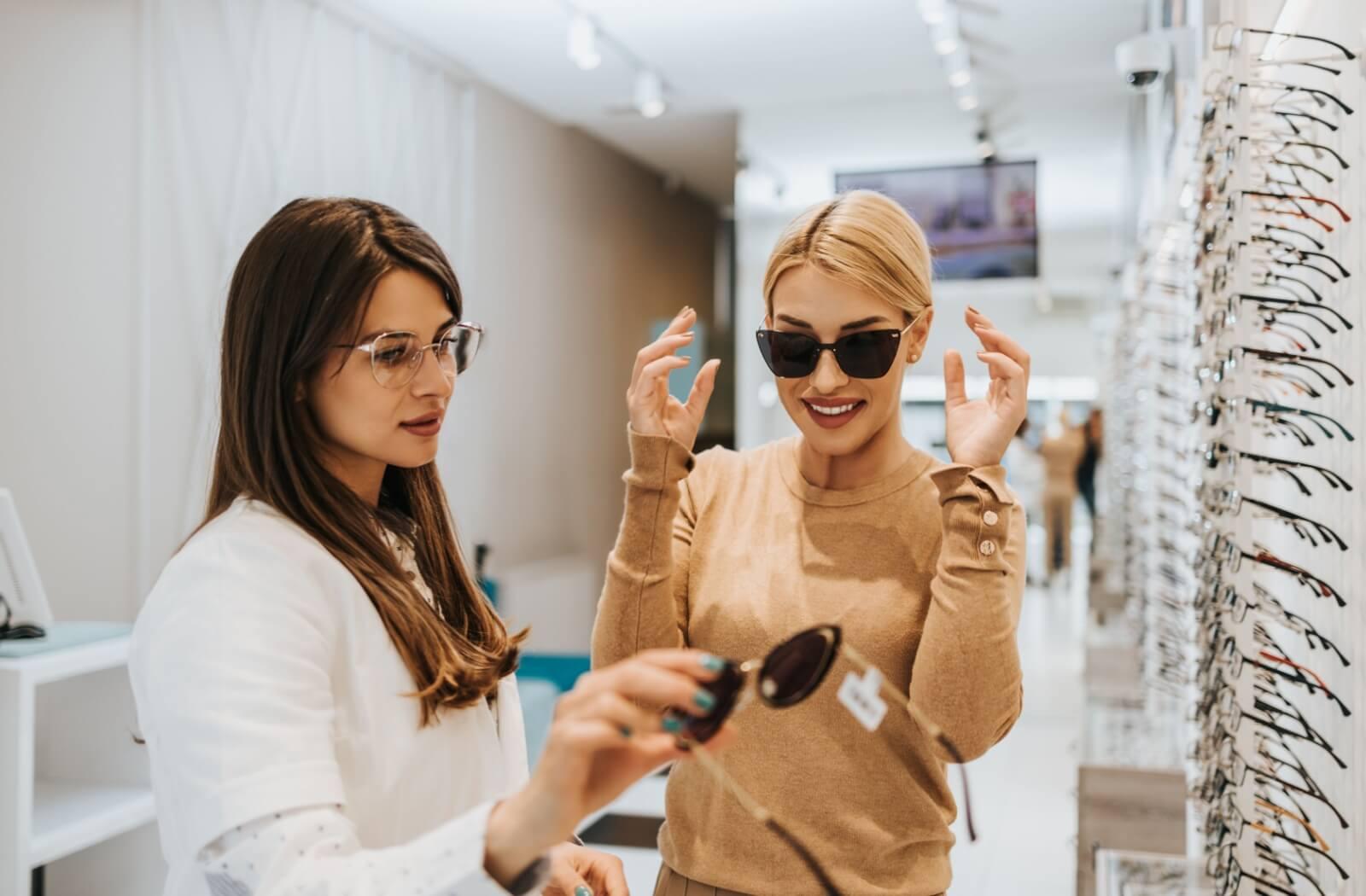 An optician helps a patient select a new pair of sunglasses.